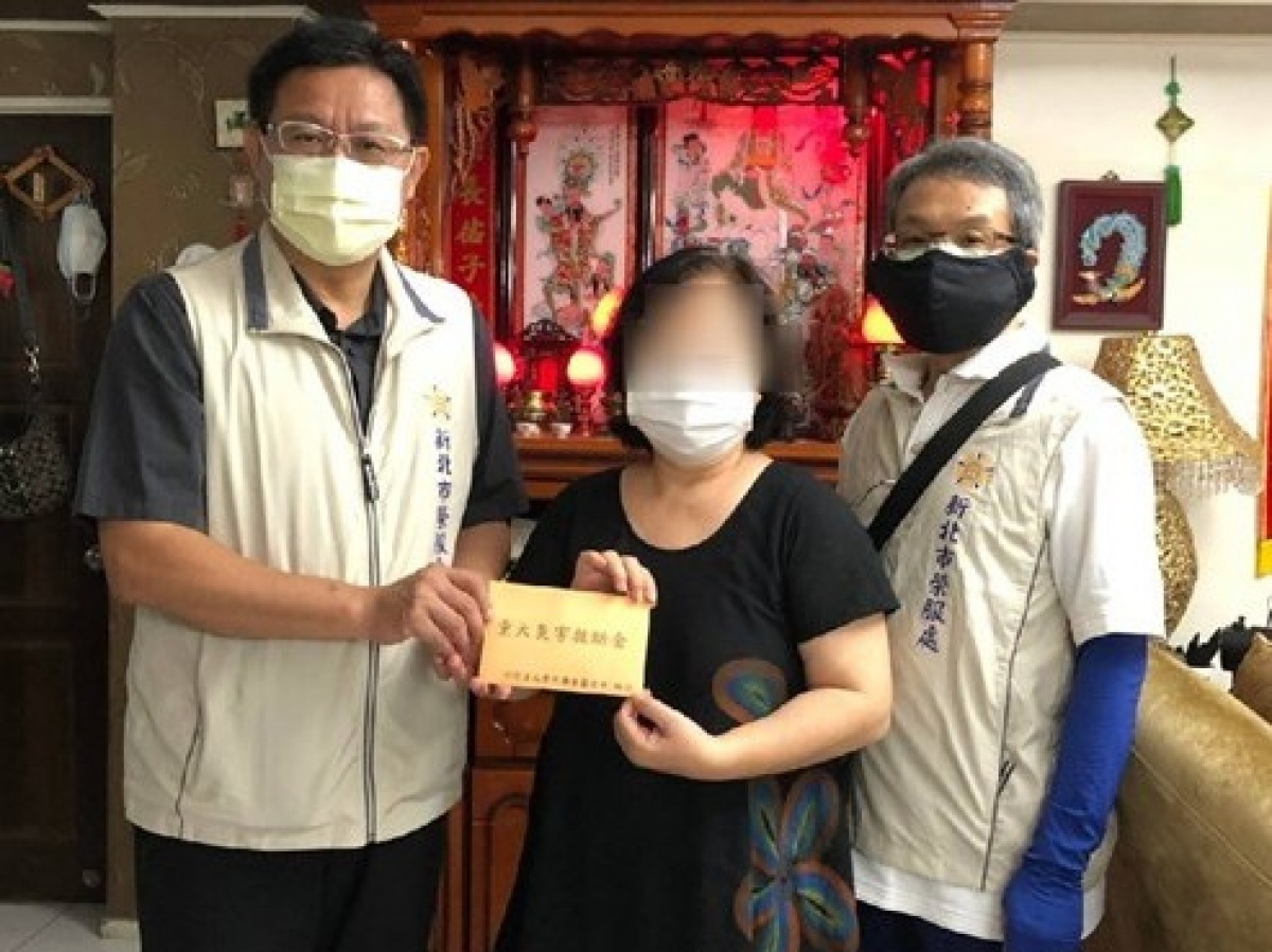 李復鄉總幹事(左)親至遺眷周女士(中)家中轉發榮民榮眷基金會重大災害救助金，並致贈養生食品等物資