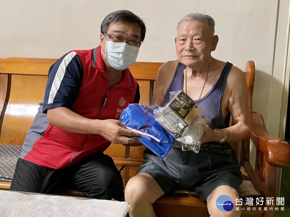新北市榮服處李毓錫副處長(左) 轉贈陸伯伯(右)排汗衣及善心企業捐贈的防疫物資