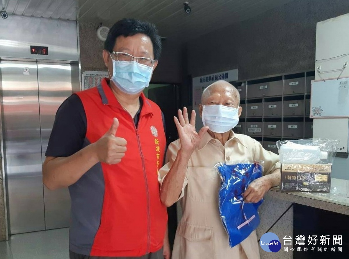 新北市榮服處李復鄉總幹事(左)轉贈汪伯伯(右)排汗衣及防疫物資。