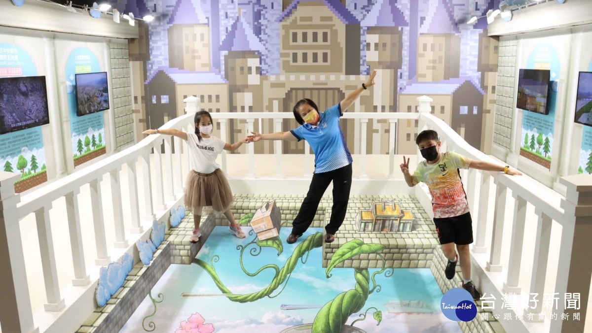 康秋桂局長(中)與小朋友於東側城堡展區3D地貼合影。
