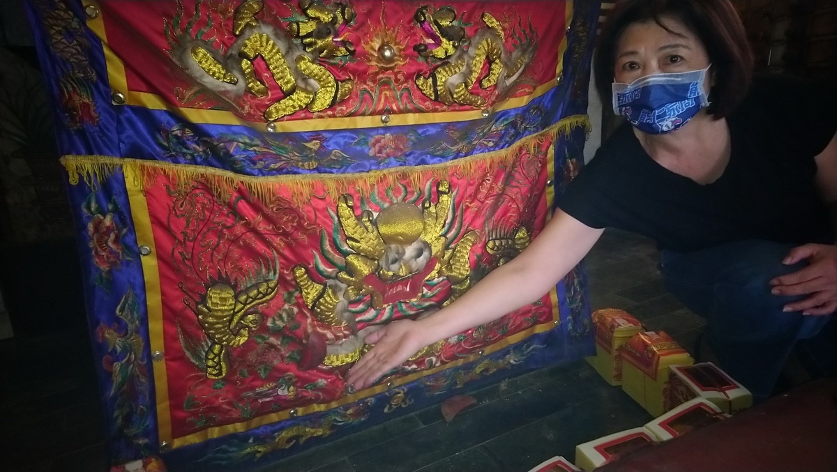 「黏」在紅色的桌裙上面的筊杯,用金紙將周圍圍起來(記者吳素珍攝)