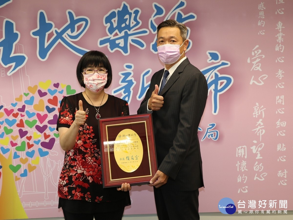 新北市社會局長張錦麗代表侯友宜市長致贈感謝牌給虹韻總經理王安(右)