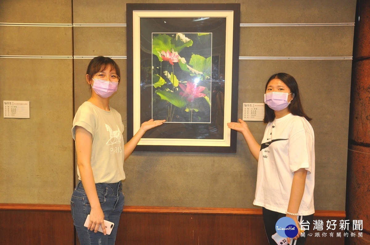 國科大親善服務團學生柯詠婕(左)、王榆婷(左)幫老師的攝影作品做導覽